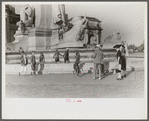 Tourists arriving at Washington, D.C. Throwing pennies to colored boys in fountain across from Union Station