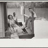 Family on front porch of houseboat on river in Charleston, West Virginia