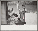 Family on front porch of houseboat on river in Charleston, West Virginia