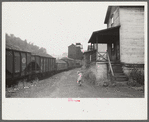 Coal miner's child taking home kerosene for lamps. Company houses, coal tipple in background. Pursglove, Scotts Run, West Virginia