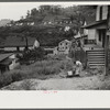 Coal miner's wife getting water from pump, company houses, Pursglove, Scotts Run, West Virginia