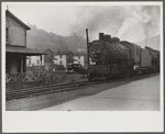 Train pulls coal through center of town past miners' homes (company houses) several times morning and evening. Osage, West Virginia