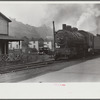Train pulls coal through center of town past miners' homes (company houses) several times morning and evening. Osage, West Virginia