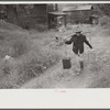 Mexican miner carrying water up the hill to his home, about two miles. Bertha Hill, West Virginia