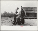 Mr. Ellis Adkins and his son, rural rehabilitation borrowers, examining new cultivator bought with FSA (Farm Security Administration) loan. There are nine in the family and this is their first year on the program. Coffee County, Alabama