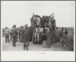 Vegetable workers, migrants, waiting after work to be paid. Near Homestead, Florida