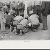 Vegetable workers, migrants, waiting after work to be paid. Near Homestead, Florida