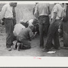 Vegetable workers, migrants, waiting after work to be paid. Near Homestead, Florida