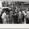Vegetable workers, migrants, waiting after work to be paid. Near Homestead, Florida