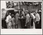 Vegetable workers, migrants, waiting after work to be paid. Near Homestead, Florida