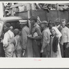 Vegetable workers, migrants, waiting after work to be paid. Near Homestead, Florida