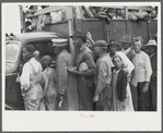 Vegetable workers, migrants, waiting after work to be paid. Near Homestead, Florida