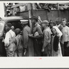 Vegetable workers, migrants, waiting after work to be paid. Near Homestead, Florida