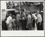 Vegetable workers, migrants, waiting after work to be paid. Near Homestead, Florida