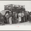 Vegetable workers, migrants, waiting after work to be paid. Near Homestead, Florida