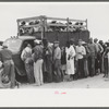 Vegetable workers, migrants, waiting after work to be paid. Near Homestead, Florida