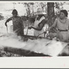 Skimming the boiling cane juice to make sorghum syrup at cane mill near Carr, Orange County, North Carolina