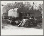 Fixing truck in front of tents of Mexican labor brought from Texas by contractor for the duration of cotton picking season. Hopson Plantation, near Clarksdale, Mississippi Delta, Mississippi