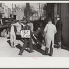 Tobacco auctioneer who "bet on Carolina" and lost, pays off the wager by pushing the warehouseman in a wheelbarrow from the warehouse to the courthouse. Durham, North Carolina