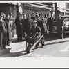 Tobacco auctioneer who "bet on Carolina" and lost, pays off the wager by pushing the warehouseman in a wheelbarrow from the warehouse to the courthouse. Durham, North Carolina