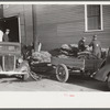 Farmers and warehousemen unloading tobacco on sidewalk before auction sales. The warehouse was too overloaded to permit more tobacco being brought in. Mebane County, North Carolina