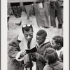 Baldwin showing small book to children, Louisiana, 1963
