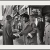 Baldwin shaking hands with man by Apollo Theater