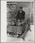 Hauling water in milk cans because usual source of supply is frozen. Putney Homestead farm near Woodstock, Vermont