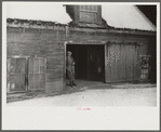 Hired man in doorway of barn on Putney Homestead near Woodstock, Vermont