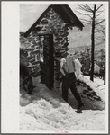 Forest ranger bringing in supplies which he has carried up the mountain on skiis to his hut which is also used by skiers in the winter. About half an hour later on his next trip down the mountain on skiis for more supplies he broke his leg