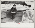 Young daughter of Frank H. Shurtleff sitting outside sugar house where sap from maple trees is boiled down into maple syrup. The Shurtleff farm has about 400 acres and was