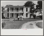 Priest going into rectory on church grounds during St. Thomas church picnic. Near Bardstown, Kentucky