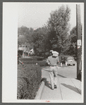 Man carrying home supplies on Saturday afternoon, Jackson, Kentucky