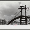 Mountaineers crossing the Kentucky River over swinging bridge, carrying their supplies home from Jackson. Breathitt County, Kentucky