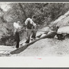 Mountaineers crossing the Kentucky River over swinging bridge, carrying their supplies home from Jackson, Breathitt County, Kentucky