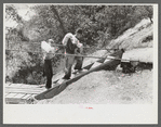 Mountaineers crossing the Kentucky River over swinging bridge, carrying their supplies home from Jackson, Breathitt County, Kentucky