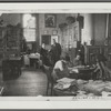 Reproduction of Photograph of Schomburg greeting a visitor, probably Mr. Oshidd, in the reading room of the collection with William Edouard Scott's "Blind Sister Mary" visible above them