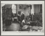 Reproduction of Photograph of Schomburg greeting a visitor, probably Mr. Oshidd, in the reading room of the collection with William Edouard Scott's "Blind Sister Mary" visible above them