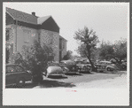 Cars parked in yard of private home across from Pratt and Whitney, United Aircraft. They charge fifty cents a week or ten cents a day. They have about 400 cars every twenty-four hours. East Hartford, Connecticut