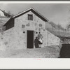 Mrs. S. Castle or Mrs. William S. Allen with canned goods in front of new storage house her husband built on their farm with FSA (Farm Security Administration) help. Southern Appalachian project, near Barbourville, Knox County, Kentucky