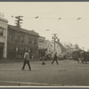 View of a busy intersection. Showing drugstore, E.J. Pray Meats,
laundry, streetcar. Hempstead