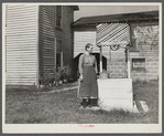 Farm woman standing by well. West Virginia