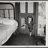 Why open the door, coal miner's child uses the "cat hole." Bertha Hill, West Virginia (Note pipe in one hand, gun in other)