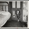 Why open the door, coal miner's child uses the "cat hole." Bertha Hill, West Virginia (Note pipe in one hand, gun in other)