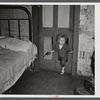 Why open the door, coal miner's child uses the "cat hole." Bertha Hill, West Virginia (Note pipe in one hand, gun in other)
