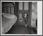 Why open the door, coal miner's child uses the "cat hole." Bertha Hill, West Virginia (Note pipe in one hand, gun in other)