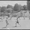 Performers in shorts rehearsing fight choreography outside with sticks for the stage production Henry IV, Part I at the Delacorte Theater
