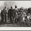 Negro agricultural laborers watching one of their houses burn to the ground. All they have left is piled on the ground