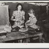 Woman migrant packinghouse worker and her oldest child fixing supper. She has three other children. Belle Glade, Florida