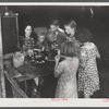 Woman migrant packinghouse worker from Tennessee with four children and two relatives eating supper. Belle Glade, Florida